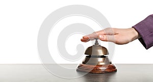 Woman ringing hotel service bell at stone table