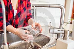 Woman is rinsing the glass with water