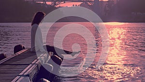 Woman on river boat station, swinging bare feet, Summer beach, Porto in sunset