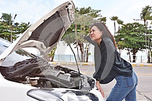 Woman on the road having problem with a Broken down car