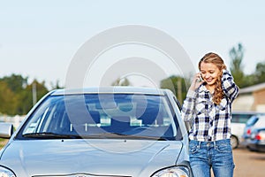 Woman on the road near a broken car calling for help