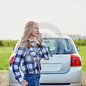 Woman on the road near a broken car calling for help