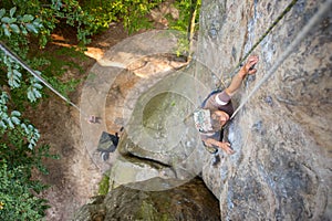 Woman rock climber is climbing on a rocky wall