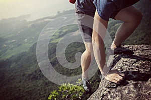 Woman rock climber on mountain peak