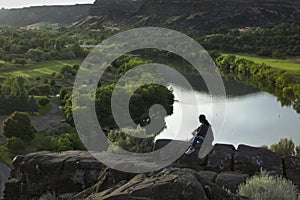 Woman on rock enjoys the river view