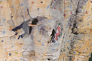 Woman on rock wall in sport centre