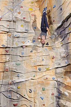 Woman on rock wall in sport centre