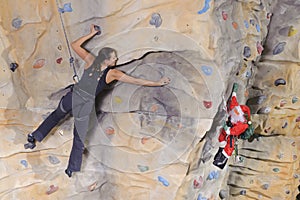 Woman on rock wall in sport centre