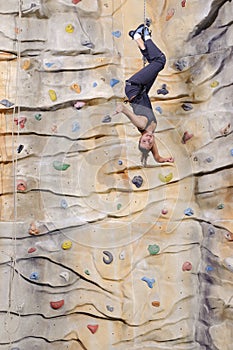 Woman on rock wall in sport centre