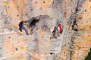 Woman on rock wall in sport centre