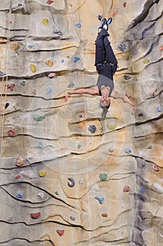 Woman on rock wall in sport centre