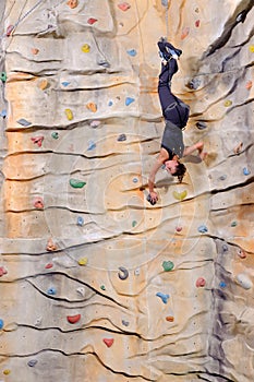 Woman on rock wall in sport centre