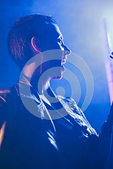 Woman rocker holding electric guitar playing heavy metal song in studio preparing performance