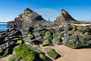 Woman on the rocks at Praia da Samoqueira beach in Portugal photo