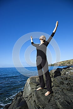 Woman on rocky coast.