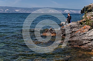 Woman on a rocky shore near the water of Lake Baikal