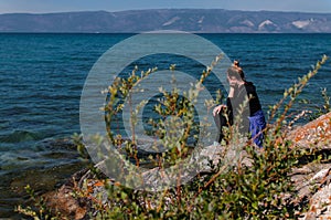 Woman on a rocky shore near the water of Lake Baikal