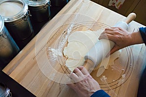 Woman rolling pie crust on a wooden board