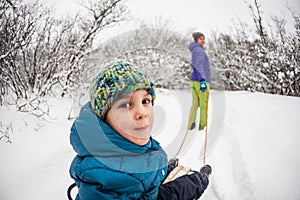 A woman rolls a boy on a sled