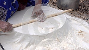 Woman rolls out tranditional Iranian Qashqai flat bread 1 - starts from puck of dough