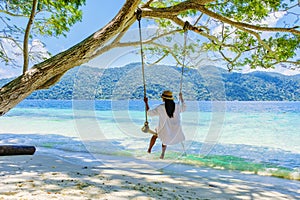 woman at a rope swing on the beach of Koh Lipe Island Southern Thailand photo