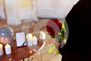 Woman with roses and cremation urn at funeral