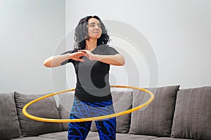 Woman rotating hula hoop. Girl training at home. Healthy sporty lifestyle