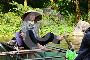 Woman rowing the boat on Ngo river. Tam Coc. Ninh Binh. Vietnam