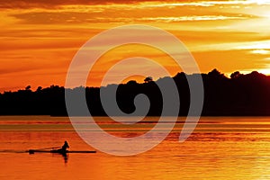 Woman rowing and training at sunset