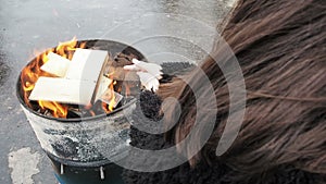 Woman Rubbing Hands in Front of Burning Fireplace. Girl is Warming Herself During Winter of Fire in a Round Barrel