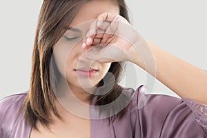 Woman rubs her eye with a finger