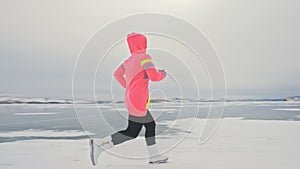 Woman run on ice in winter is do sport in athletic race walking. Girl is training in winter on ice. Sports nordic power