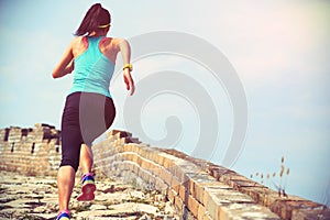 Una donna corridore atleta correre sul marciapiede sul cinese il grande parete 