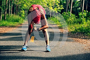 Woman runner have a rest checking the sports watch