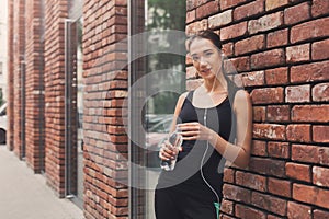 Woman runner is having break, drinking water