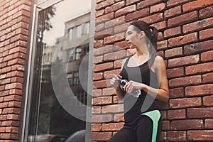 Woman runner is having break, drinking water