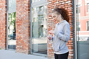 Woman runner is having break, drinking water