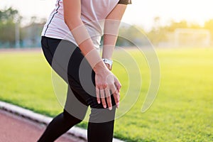Woman runner having a knee pain and injury after running,Female hands touching her knees