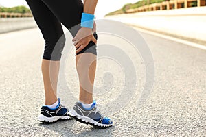 Woman runner hold her injured leg