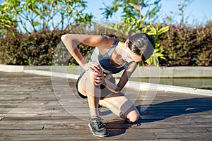 Woman runner hold her sports injured knee