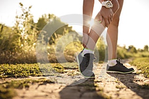 Woman runner hold her sports injured leg