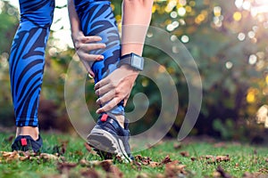 Woman runner hold her sports injured leg. Sport, medicine and pe