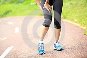 Woman runner holder her sports injured legs