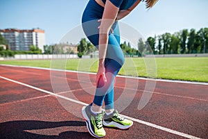 Woman runner holding her sports leg injure