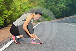 Woman runner hurting holding painful sprained ankle