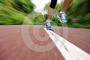 Woman runner legs running at forest trail