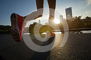 woman runner legs running on sunrise city