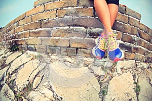 Woman runner legs sit on great wall