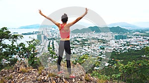 Woman runner raise hands up in the air. Female run on top of the mountain, cheering in winning gesture.