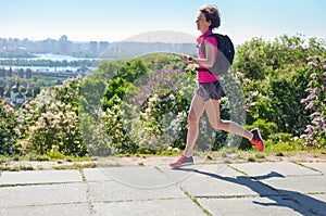 Woman runner run commutes to work with backpack, city morning run commuting and fitness concept